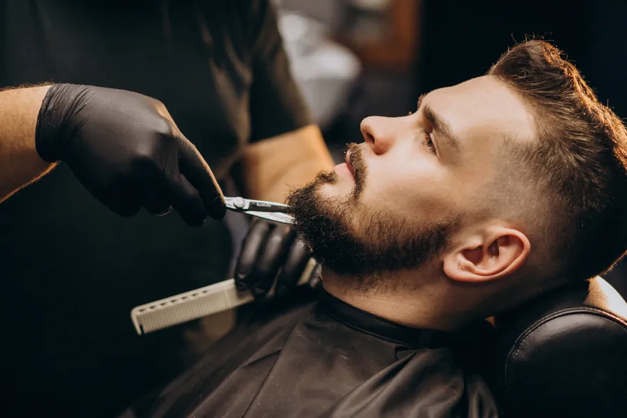Beard being shaped with a razor