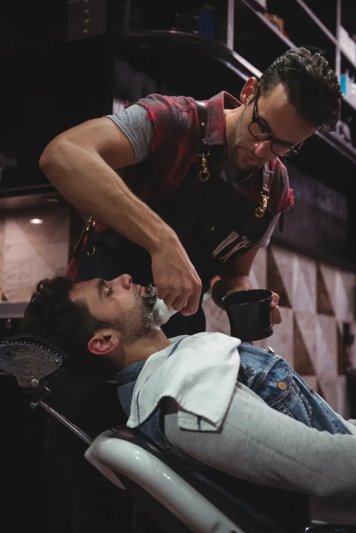 Barber applying cream to a client's beard